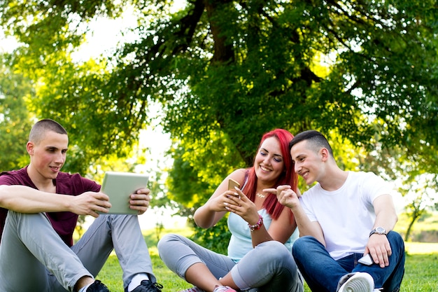 Group of young people using technology in the park