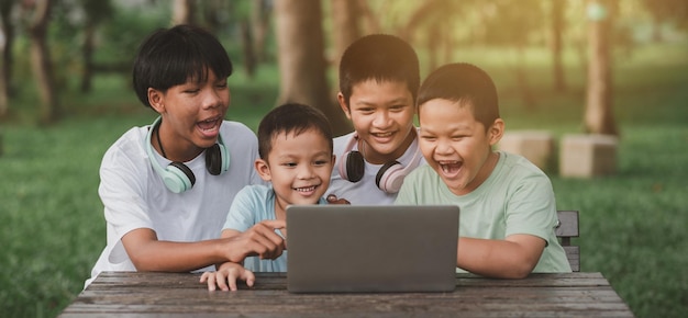 Groups of children sitting in their gardens. Children happily playing computer games.