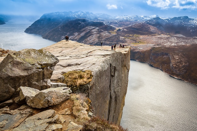 Groups of tourist standing on edge of Pulpit rock (Preikestolen)