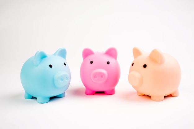 Growing investment - three piggy banks different color isolated on white