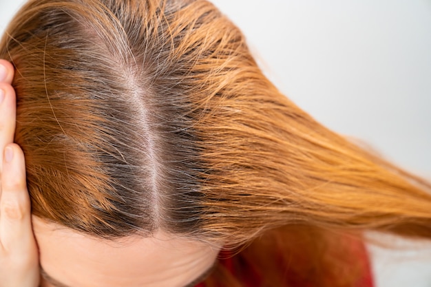 Grown after staining the gray roots of hair on the head of a woman.