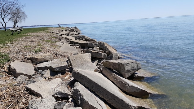 Photo groynes by sea against clear sky