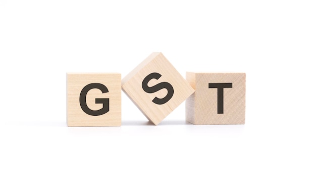 GST acronym from wooden blocks with letters Goods and Services Tax concept top view on white background