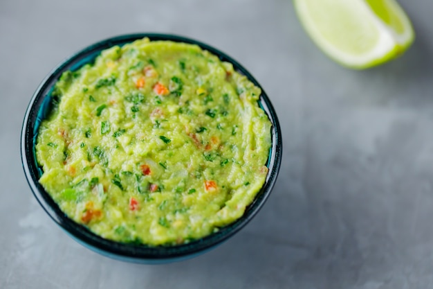 Guacamole bowl on a gray background. Traditional mexican dip sauce guacamole in the bowl. Mexican cuisine. Copy space. Top view