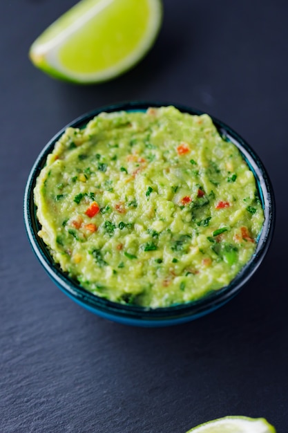 Guacamole on a dark background. Traditional mexican dip sauce guacamole in bowl. Traditional mexican food. Close-up