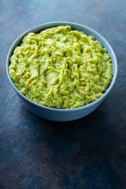 Guacamole in a gray bowl on a dark background