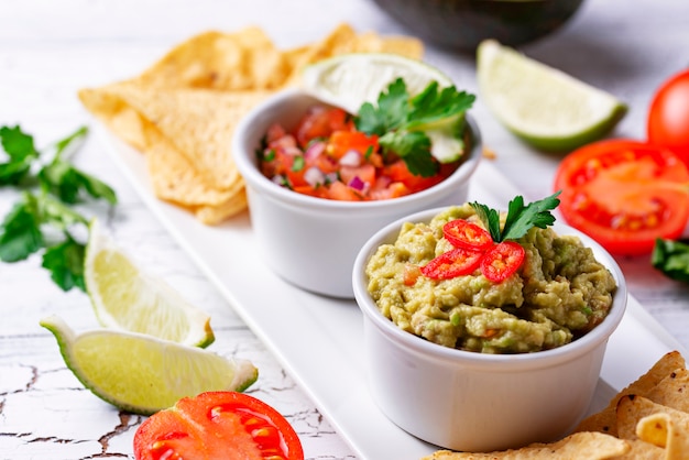 Guacamole, tomato sauce salsa and chips nachos