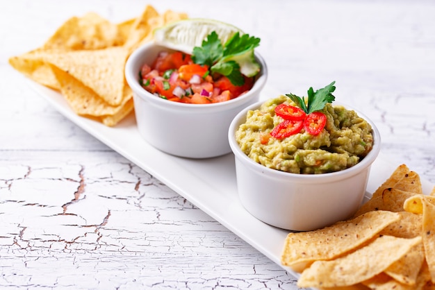 Guacamole, tomato sauce salsa and chips nachos