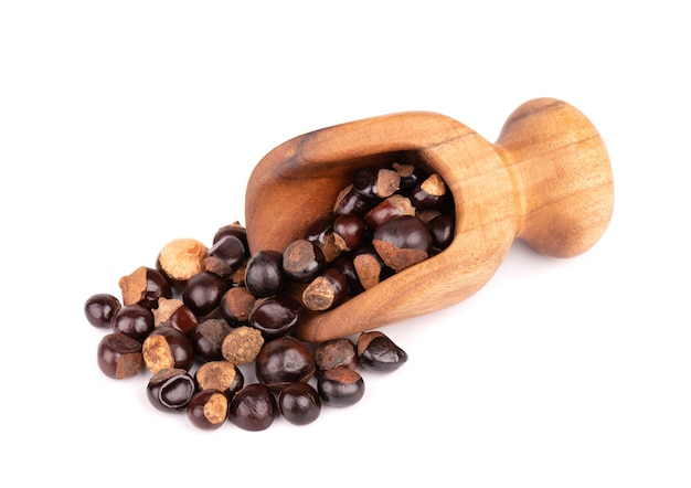 Guarana seed in wooden scoop, isolated on white surface