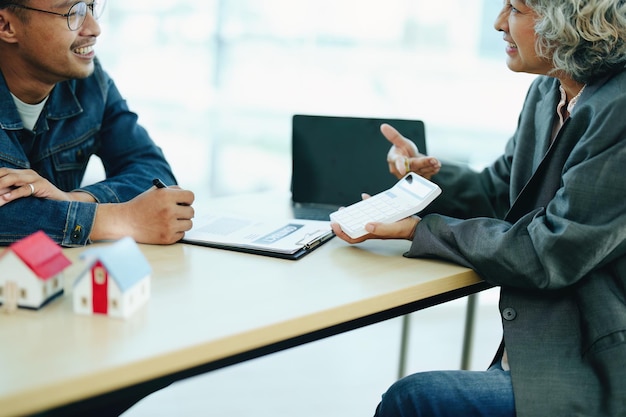 Guarantee Insurance Sign a contract couple a smiling couple is signing a contract to invest in real estate with the Mortgage officer with the bank