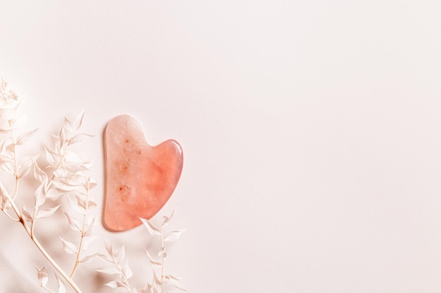 Guashe scrapes from rose quartz on pale pink background with copy space, decorated