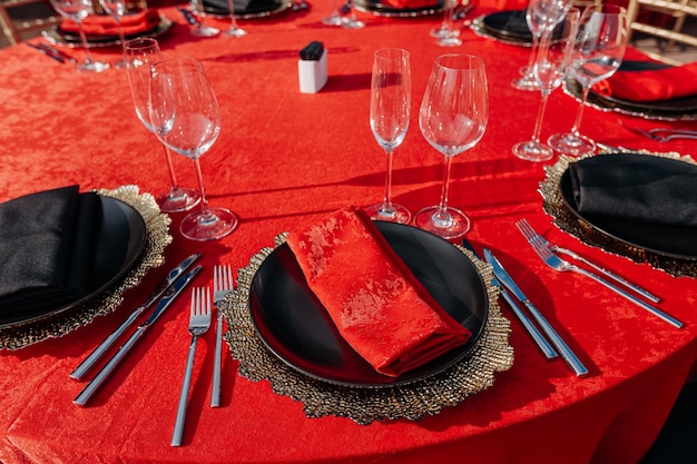 Guests table setting for banquet in black red and gold style Elegant and luxury dinner arrangement