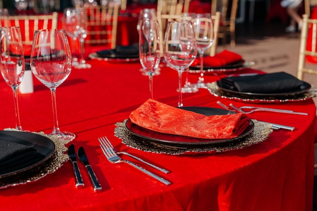 Guests table setting for banquet in black red and gold style Elegant and luxury dinner arrangement