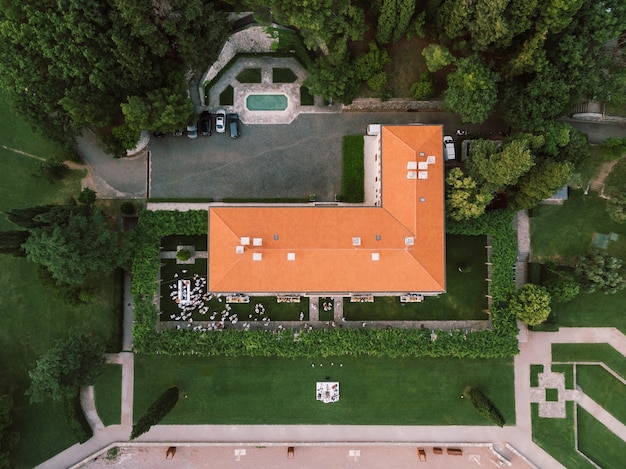 Guests in white at a wedding on the lawn in front of villa milocer top view