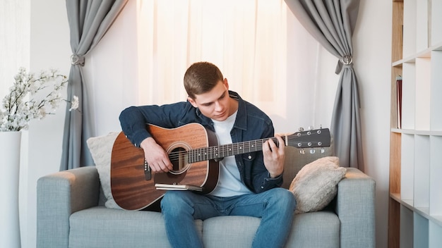 Guitar practicing music learning motivated inspired man playing melody chords on acoustic string