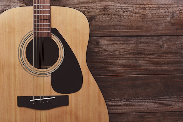 Guitar resting on old wooden background, Close up acoustic guitar - top view