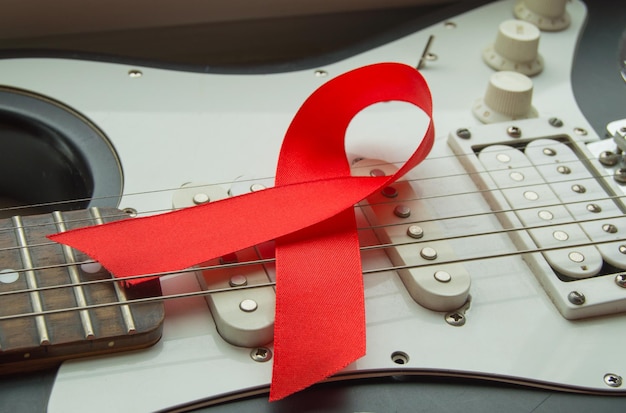 Guitar rock music and red ribbon symbol of fight against AIDS