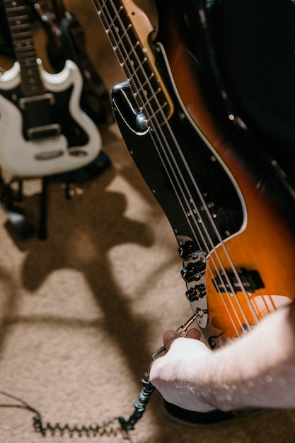 Guitarist connecting bass guitar in studio