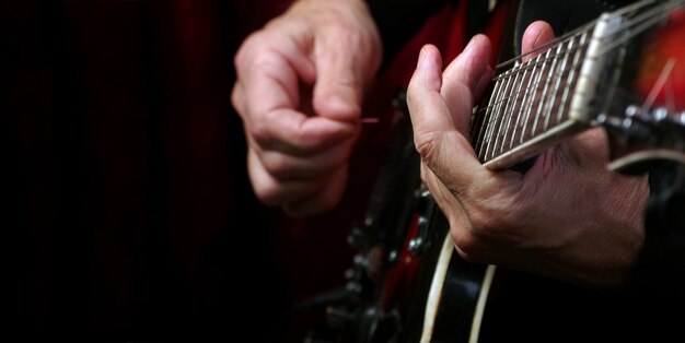 Guitarist hands and guitar on a black table close up. playing electric guitar. copy spaces.