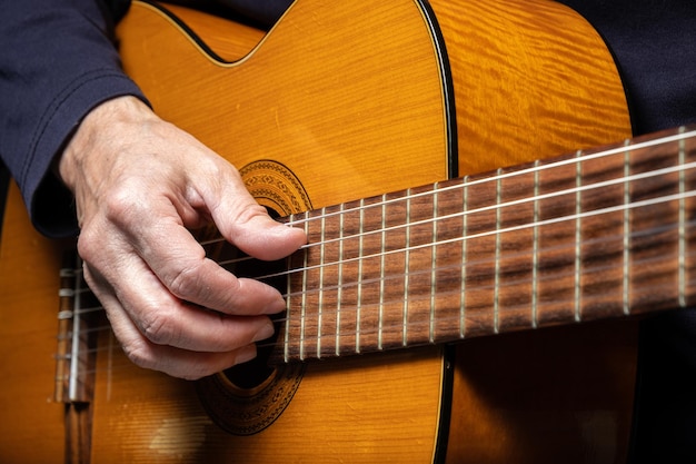 Guitarist playing acoustic guitar on black background selective focus A man playing acoustic guitar