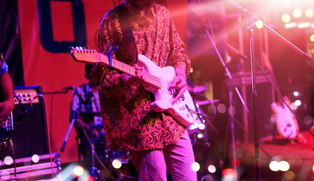  Guitarist on stage with red lighting for background. 