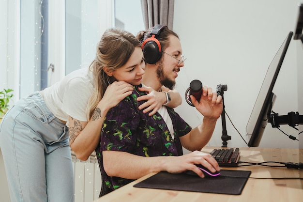 Guy blogger and his beautiful girlfriend at the desk with personal computer