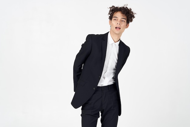 Guy in a classic suit on a light background curly hair portrait