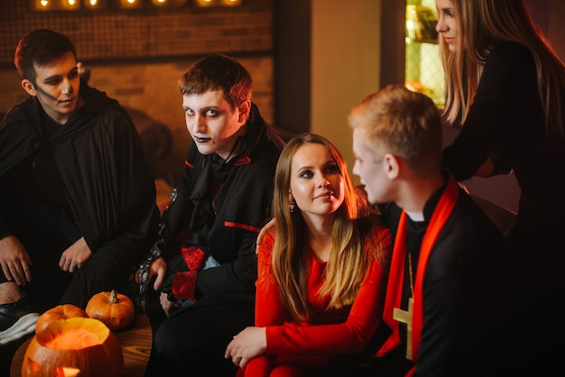 Guy in count draculas halloween costume is sitting with friends in a cafe