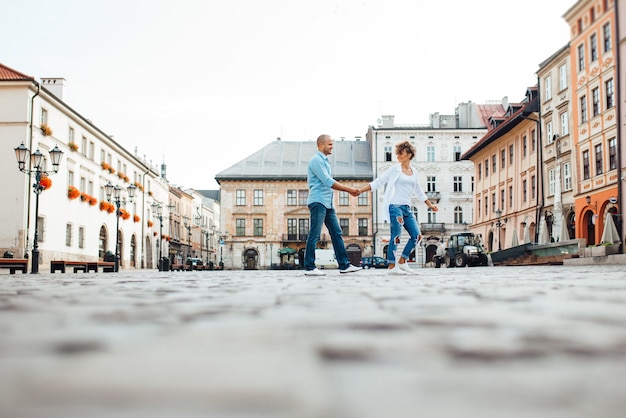 Guy and a girl happily walk in the morning on the empty streets of old Europe