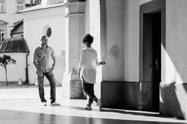 Guy and a girl happily walk in the morning on the empty streets of old Europe