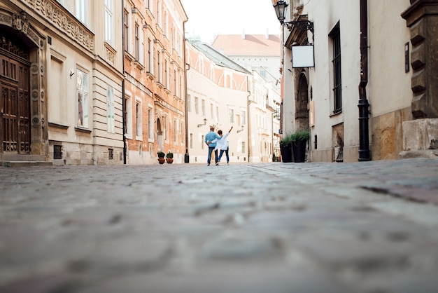 Guy and a girl happily walk in the morning on the empty streets of old Europe