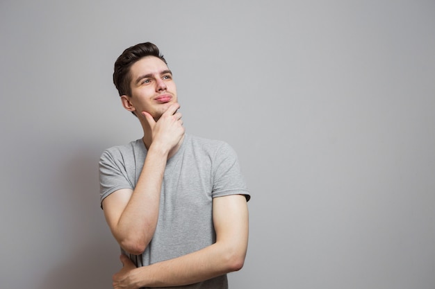 A guy in a gray T-shirt with emotions on his face.