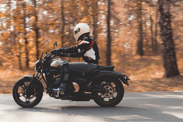 Guy in a helmet is riding on a forest road.