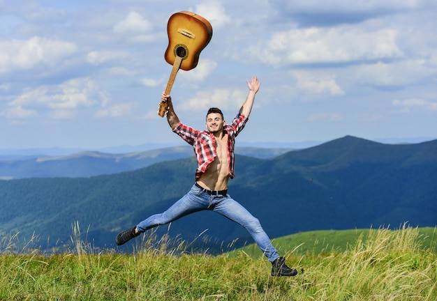 Guy hiker enjoy pure nature Man with guitar walking on top of mountain Vacation destinations Fresh mountain air Exploring nature Beauty of nature Looking for inspiration Walking alone