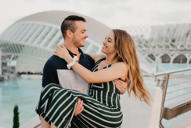 A guy is holding in his hands his girlfriend in the evening in Spain