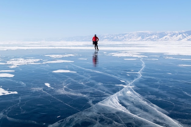 The guy is skating on the ice of Lake Baikal Winter Siberian landscape