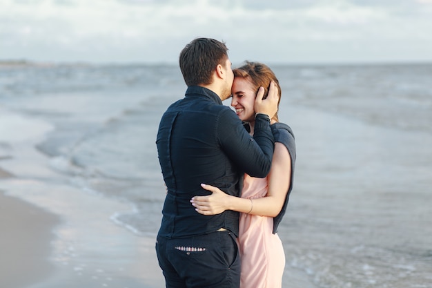 Guy kissing his girl against the sea