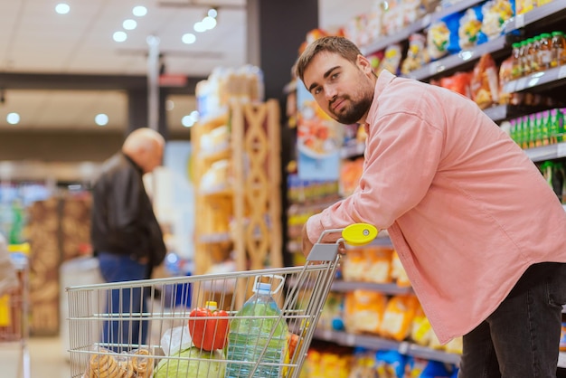 The guy makes purchases in the supermarket the concept of shopping