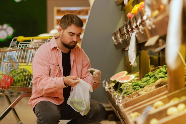 The guy makes purchases in the supermarket the concept of shopping