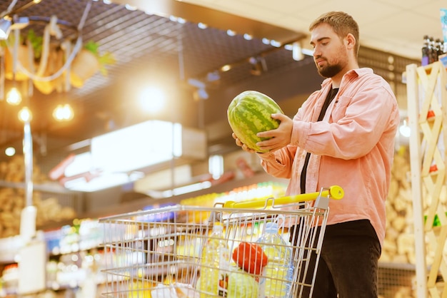 The guy makes purchases in the supermarket the concept of shopping