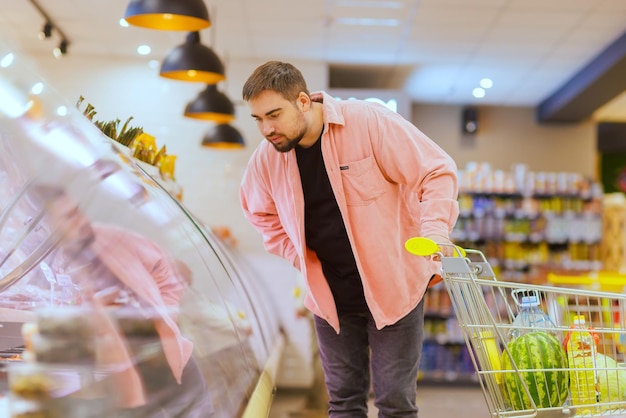 The guy makes purchases in the supermarket the concept of shopping