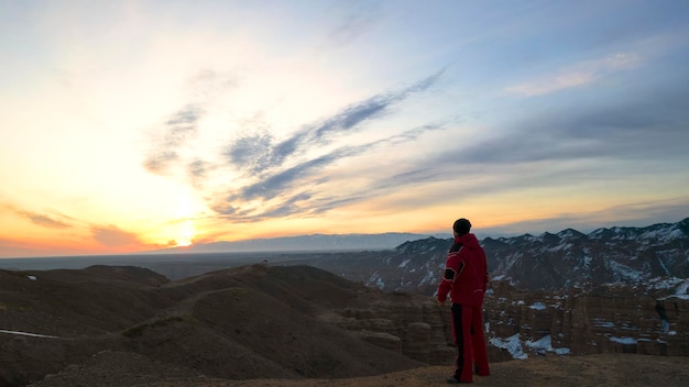 The guy in red walks to the edge of the canyon