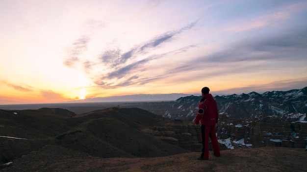 The guy in red walks to the edge of the canyon