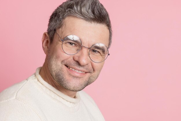 Guy in round glasses on a pink background