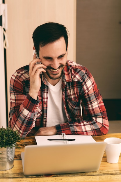 Guy in shirt using phone and drinking cofee