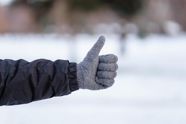 The guy shows the class in gloves Hands in gray winter gloves Palm with a glove in the snow The guy threw snow