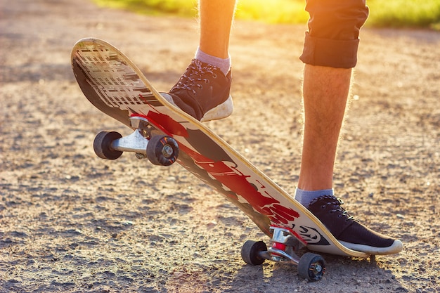 The guy stands on a skateboard is on the road beautiful toning.