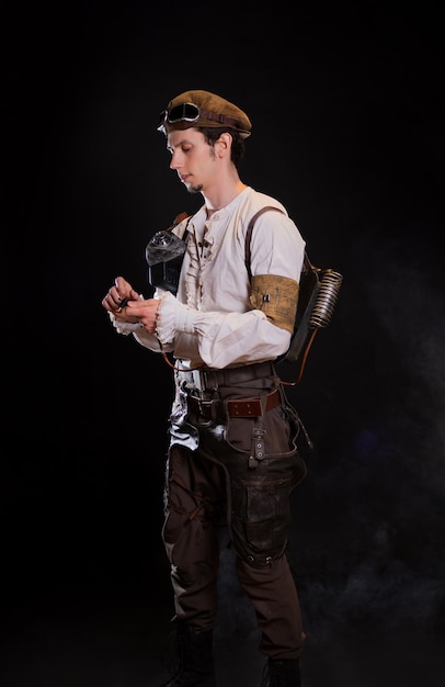 A guy in a steampunk image a pilot or a mechanic retro style fantastic image portrait on black