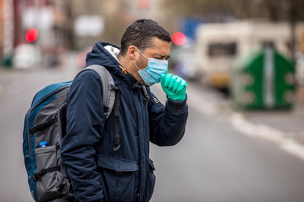 Guy wearing protective mask from virus outdoor in the people crowdy. Concept of health and safety life from coronavirus