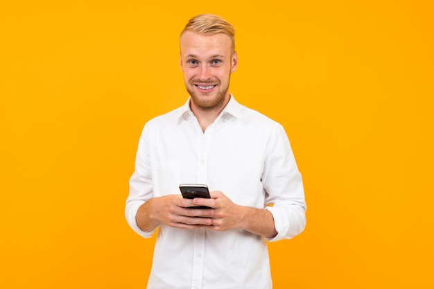 Guy in a white t-shirt with a cell phone in his hand